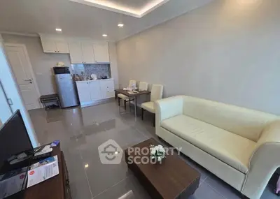Modern living room with sleek kitchen, cozy seating, and stylish decor in a contemporary apartment.