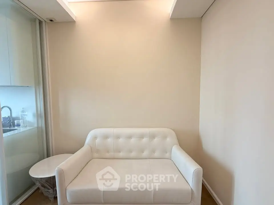 Cozy living room with elegant white sofa and side table, perfect for relaxation.