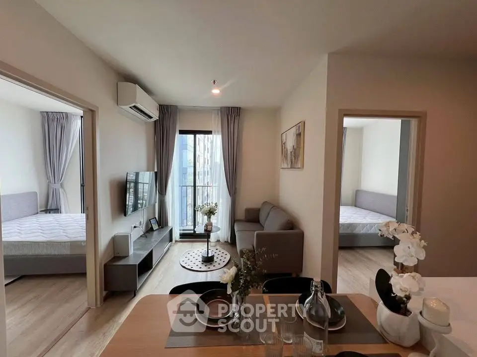 Modern apartment interior with open living room and two bedrooms, featuring stylish decor and natural light.