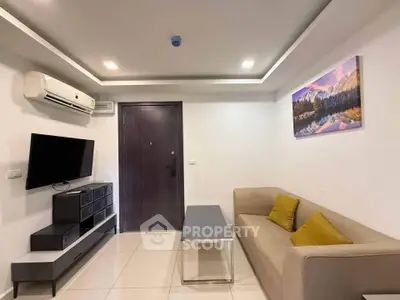 Modern living room with sleek furniture and wall-mounted TV, featuring stylish decor and air conditioning.