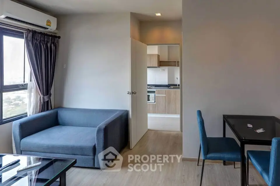 Modern living room with blue sofa and dining area in open layout apartment