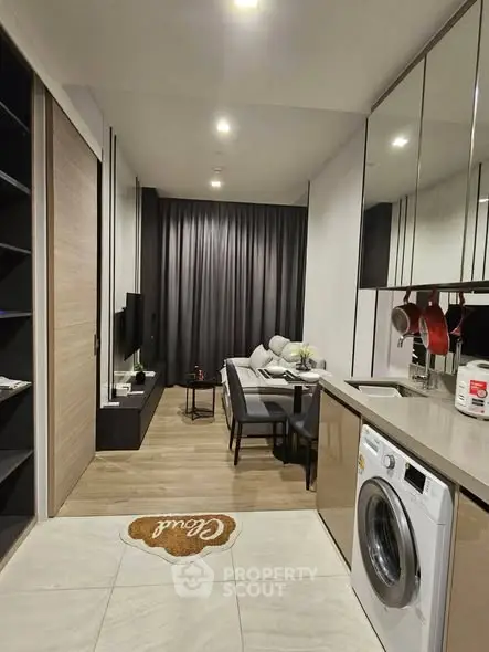 Modern open-plan living room with sleek kitchen and washing machine