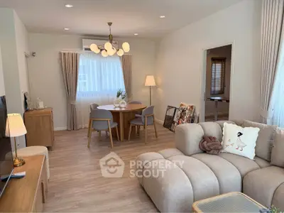 Modern living room with stylish furniture and elegant lighting, featuring a cozy dining area and soft neutral tones.