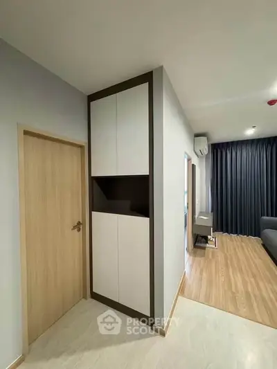 Modern living room with sleek design and wooden flooring, featuring a stylish storage unit and cozy ambiance.