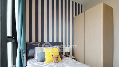 Chic modern bedroom with striped accent wall and cozy decor