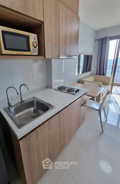 Modern kitchen with sleek cabinetry, built-in microwave, and cozy dining area with natural light.