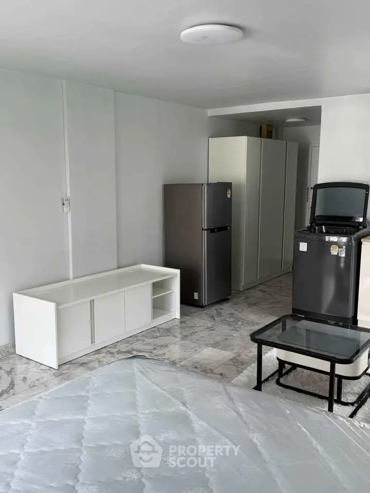 Modern apartment interior with sleek appliances and minimalist furniture design.