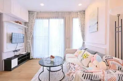 Bright and cozy living room with modern decor and large windows.