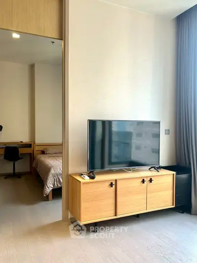 Modern living room with sleek TV stand and cozy bedroom view