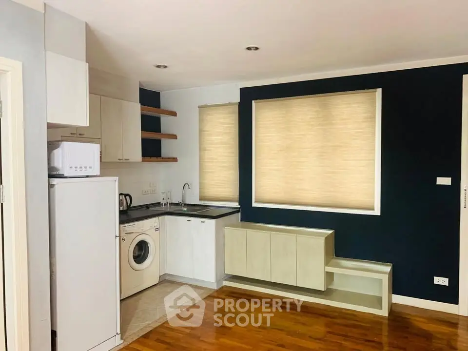 Modern kitchen with washing machine and microwave in compact layout