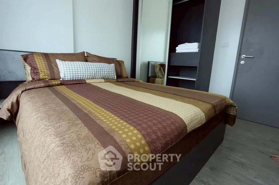 Cozy bedroom with stylish bedding and built-in closet in modern apartment.