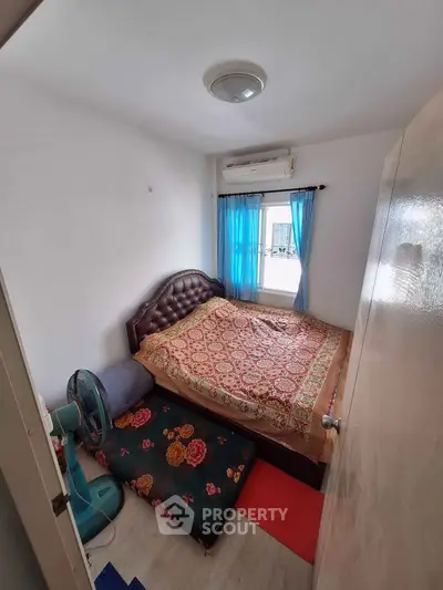 Cozy bedroom with double bed, air conditioning, and vibrant decor in a compact space.