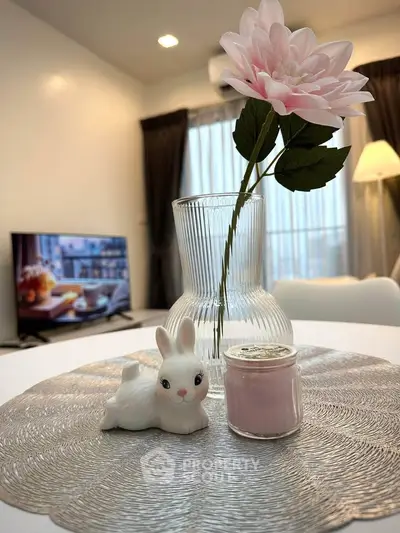 Charming living room with elegant decor, featuring a stylish vase and cozy ambiance.