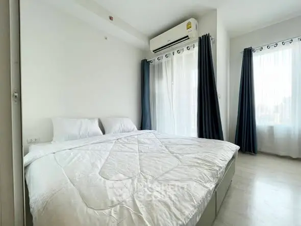 Bright and airy bedroom with large windows and modern air conditioning unit.