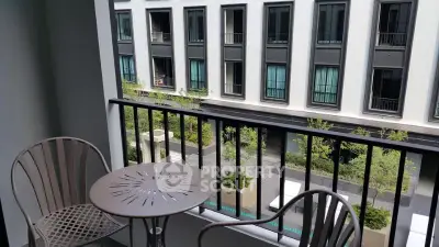 Charming balcony with modern furniture overlooking a stylish urban courtyard, perfect for relaxation.