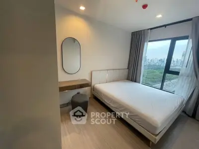 Modern bedroom with large window offering stunning city view, featuring sleek furniture and elegant decor.