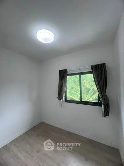 Cozy bedroom with natural light and garden view, perfect for relaxation and tranquility.