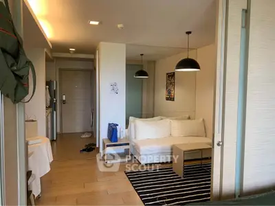 Modern living room with cozy sofa and stylish lighting in open-plan apartment.