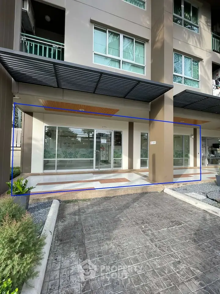 Modern building entrance with glass doors and covered walkway