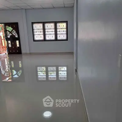 Spacious empty room with glossy tiled floor and large windows