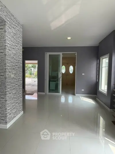 Spacious modern living area with sleek tile flooring and large windows for natural light.