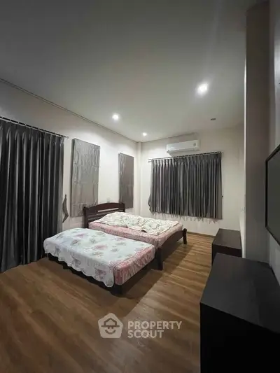 Spacious bedroom with wooden flooring and modern decor