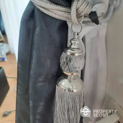 Elegant curtain tieback with silver tassel in modern interior design