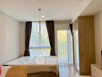 Spacious bedroom with large windows and modern decor in a stylish apartment.