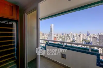 Stunning cityscape view from a high-rise balcony with glass door access, perfect for urban living.