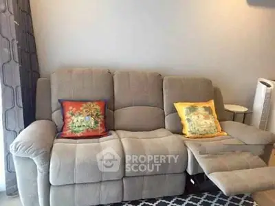 Cozy living room with plush sofa and colorful cushions, perfect for relaxation.