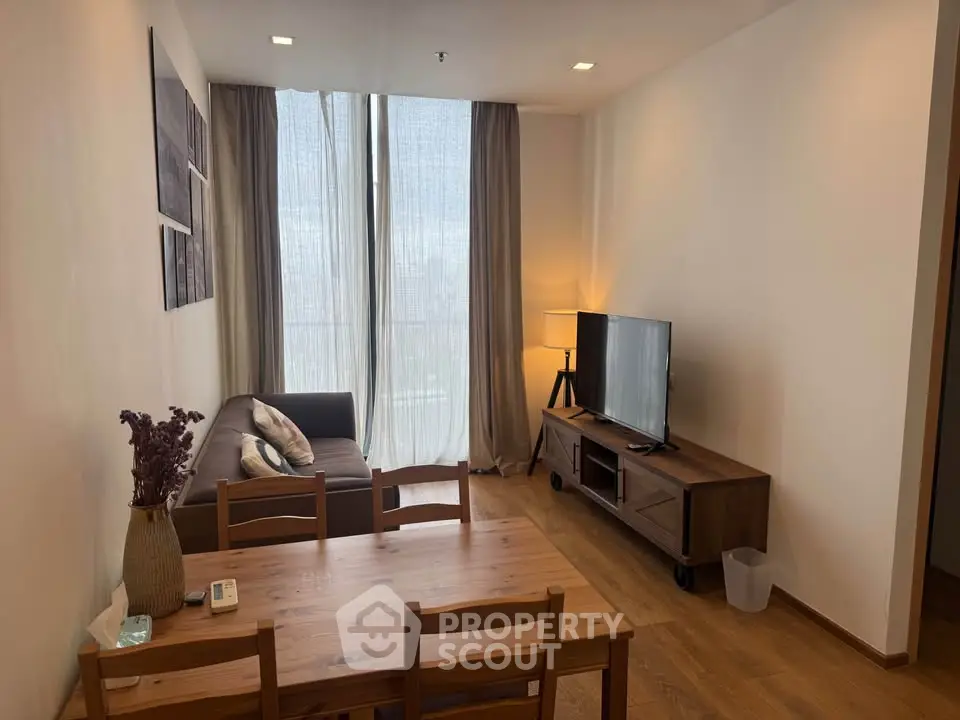 Cozy living room with wooden furniture and large window, perfect for relaxation.