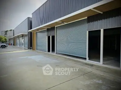 Modern commercial building with multiple garage-style entrances and sleek design.
