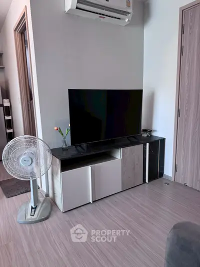 Modern living room with sleek TV stand and air conditioning, perfect for cozy relaxation.