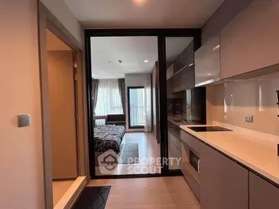 Modern studio apartment with sleek kitchen and cozy bedroom, featuring open layout and stylish design.