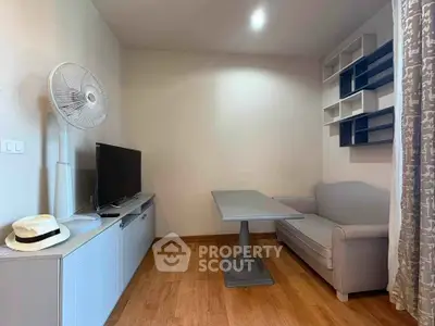 Cozy living room with modern decor, featuring a TV, sofa, and stylish shelving.