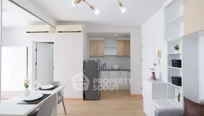 Modern open-layout kitchen with sleek cabinets and dining area in a bright apartment.