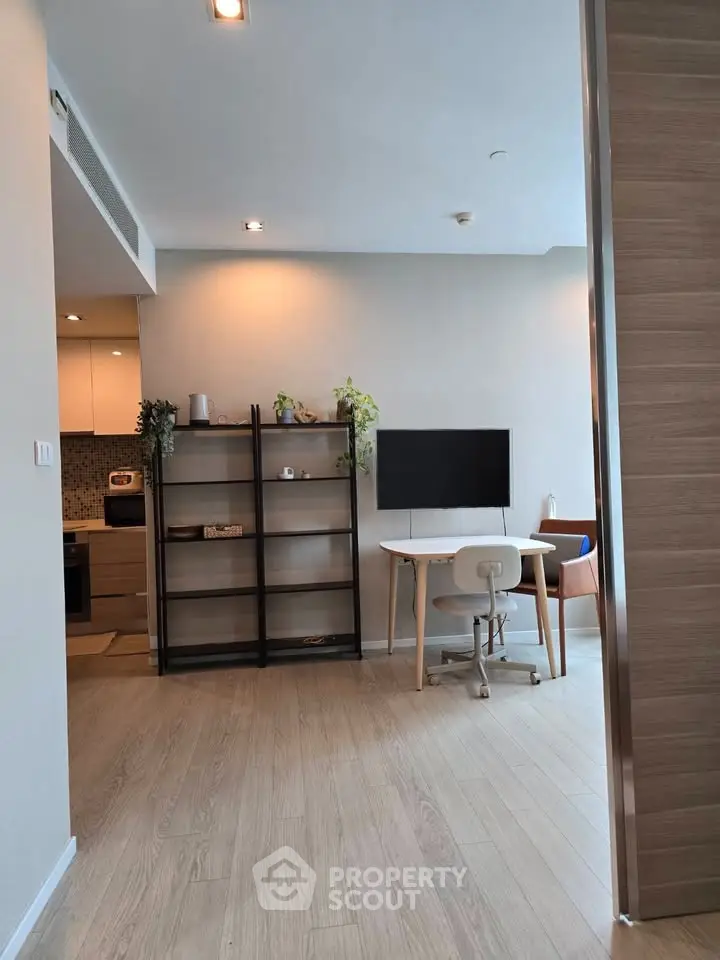 Modern living space with open layout and stylish decor, featuring a cozy study area and sleek kitchen.