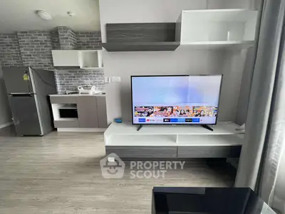 Modern living room with sleek TV setup and stylish kitchen area