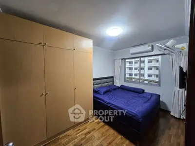 Cozy bedroom with wooden flooring and ample wardrobe space