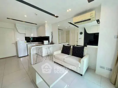 Modern living room with sleek white furniture and open kitchen layout