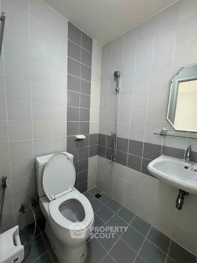 Modern bathroom with sleek tiles and contemporary fixtures in a real estate property.