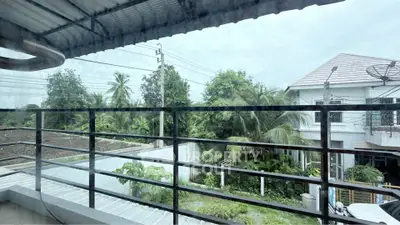 Spacious balcony with lush greenery and suburban view, perfect for relaxation and outdoor enjoyment.