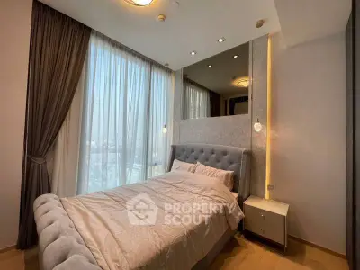 Luxurious bedroom with elegant decor and large window offering stunning city views.