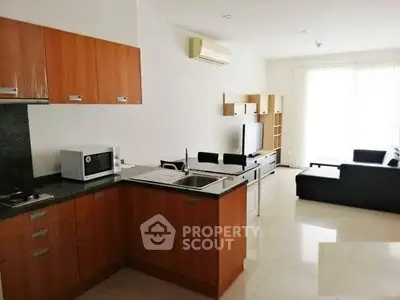 Modern open-layout kitchen and living room with sleek design and ample natural light.