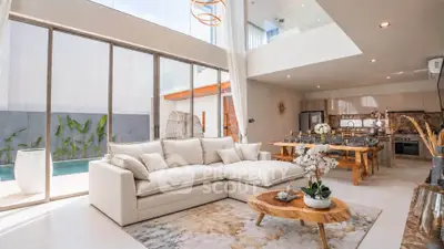 Luxurious open-plan living room with modern kitchen and pool view, featuring elegant decor and natural light.