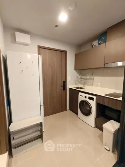 Modern compact kitchen with washing machine and sleek cabinetry
