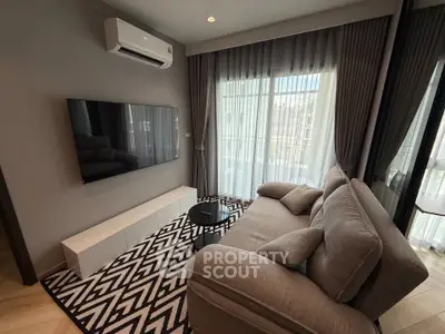Modern living room with stylish decor, featuring a large TV, comfortable sofa, and elegant curtains.