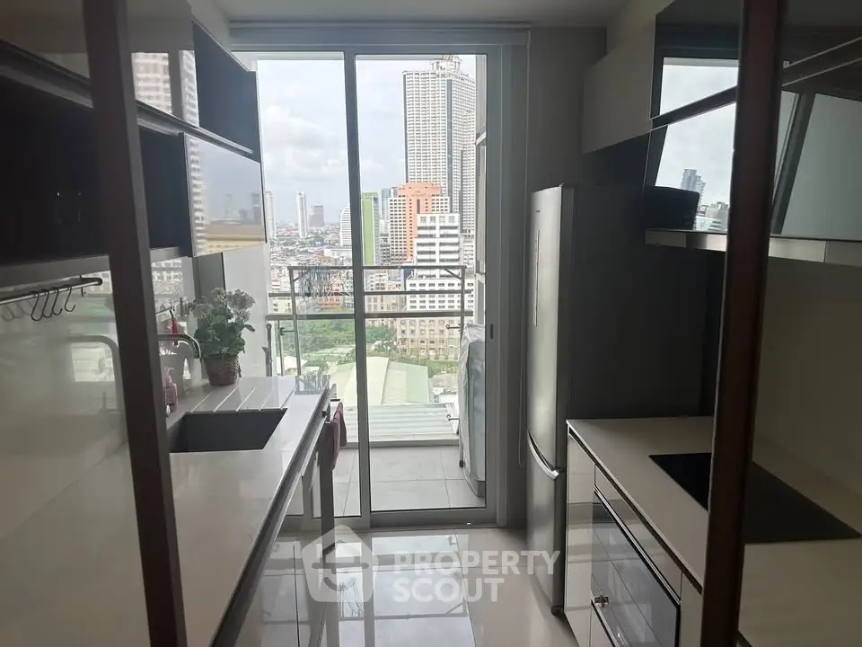 Modern kitchen with sleek design and city view from balcony, featuring high-end appliances and ample storage.