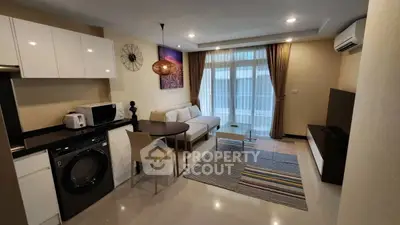 Modern living room with open kitchen, featuring sleek appliances and stylish decor.