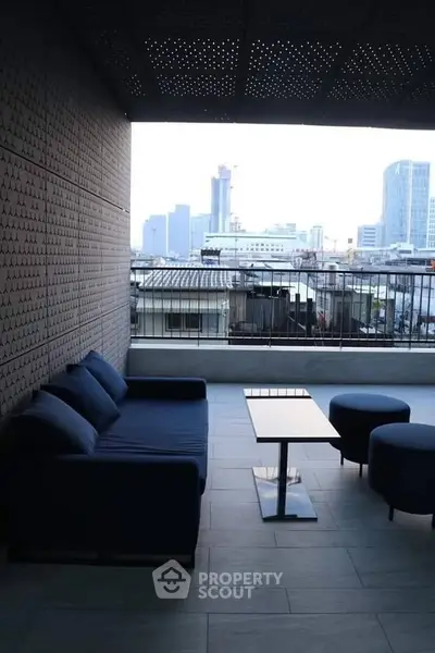 Stylish balcony with modern seating and city skyline view, perfect for urban living.